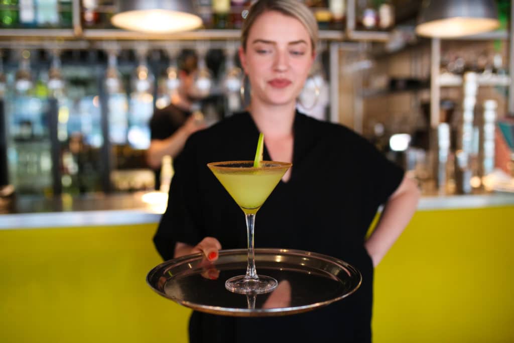 A waitress with a cocktail on a tray