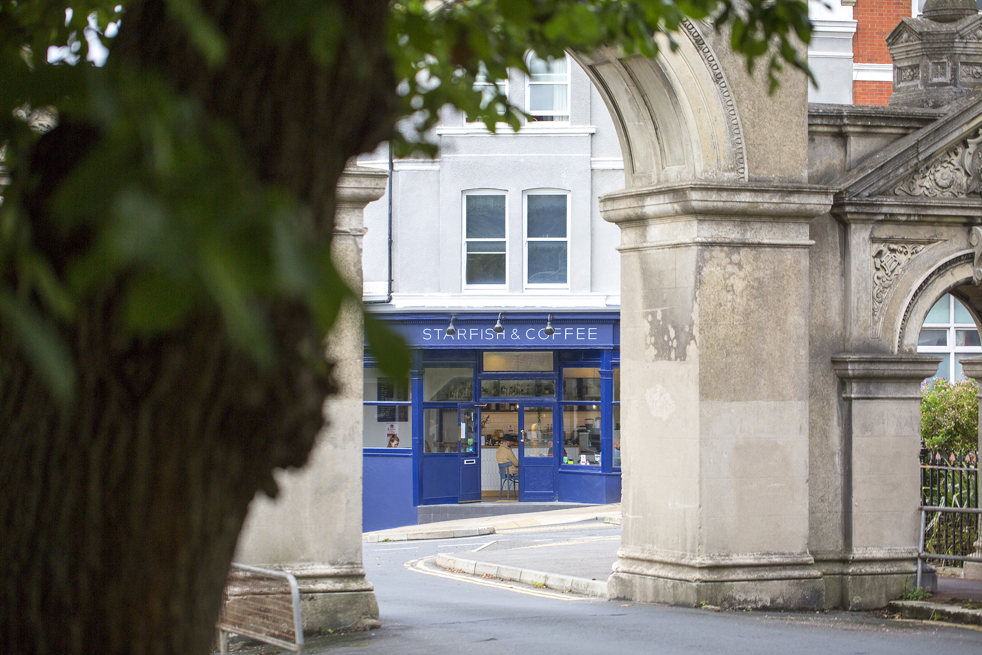 a peak of Starfish and Coffee through the concrete arch in Hanover. close to Queens Park