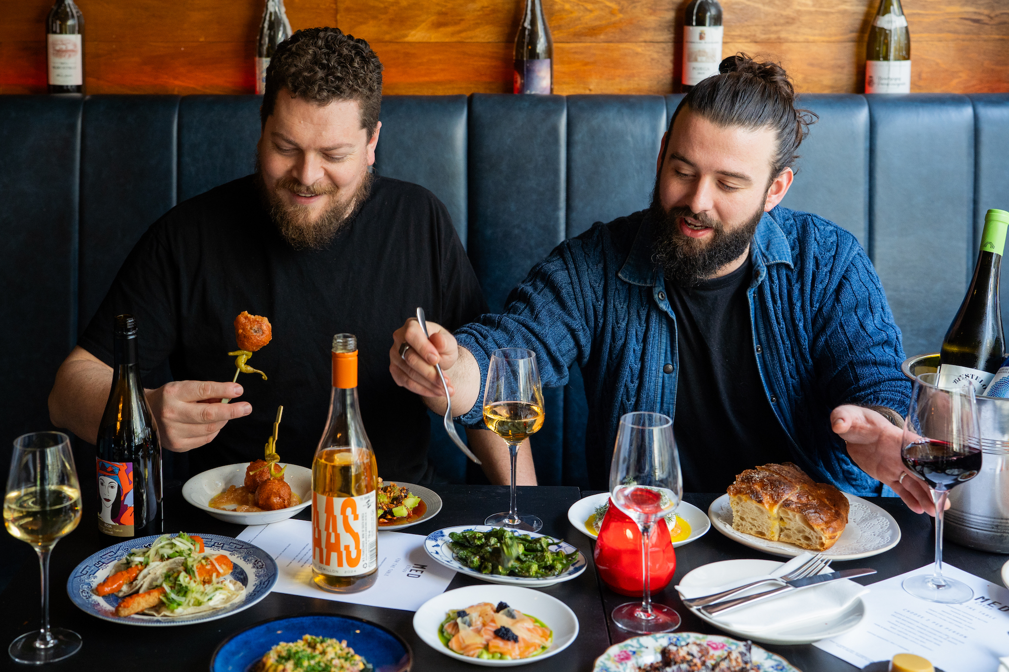 owners of med restaurant enjoying a photoshoot with Justyna and Harvey. With a table full of dishes in front of them. 