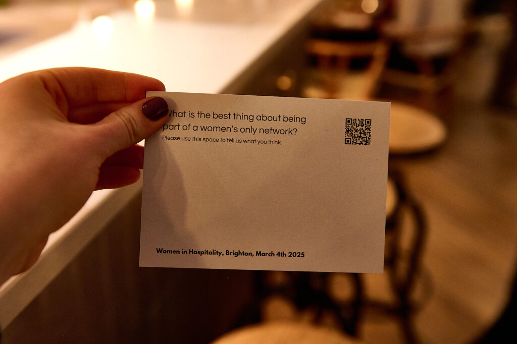 A hand holding a postcard with the question What is the best thing about being part of a women only hospitality event