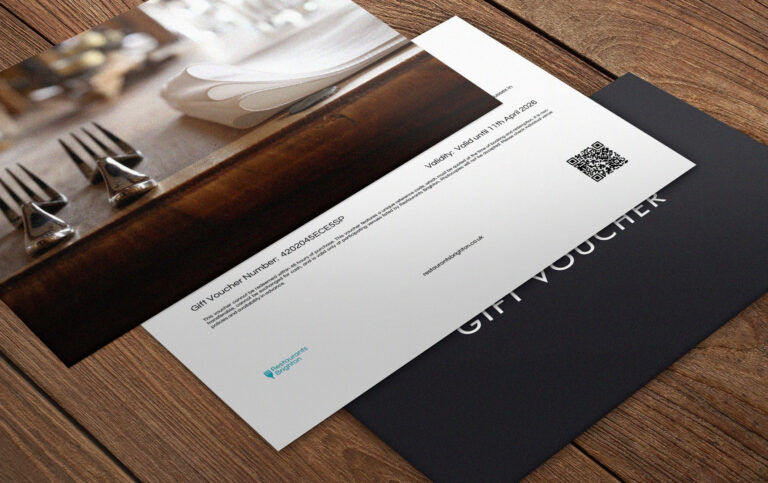 An elegant looking gift voucher laid out on a wooden table