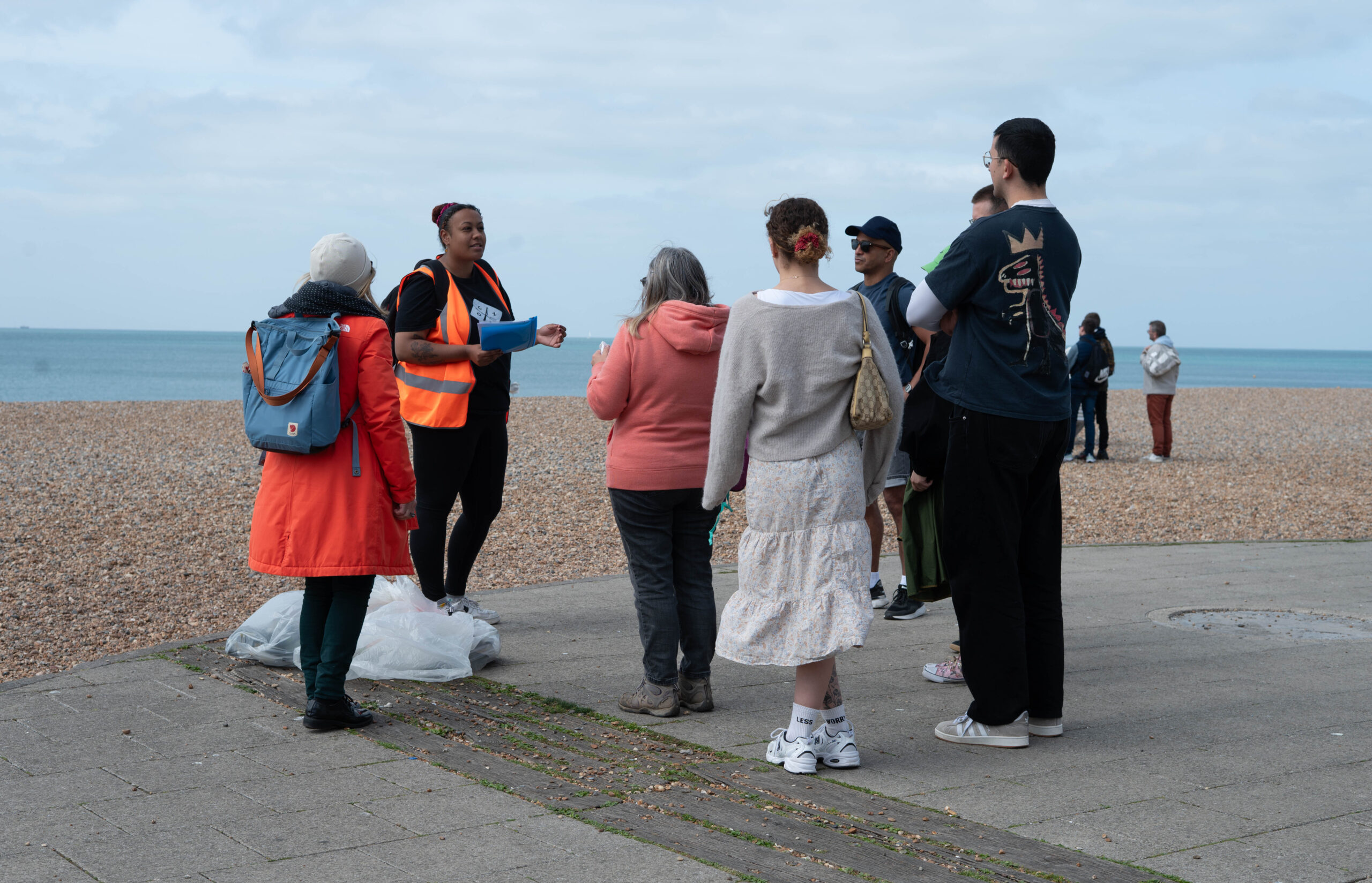 a couple of people gathered before collecing plastic waste on the beach 