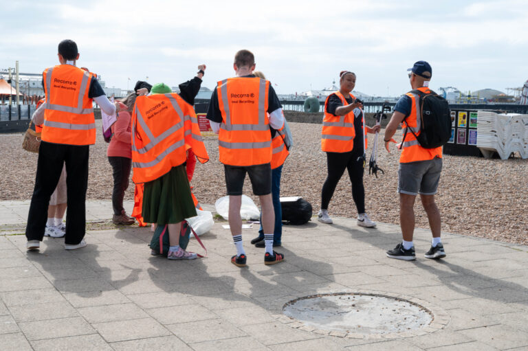 people on the beach with orange vests preparing to clean the beach
