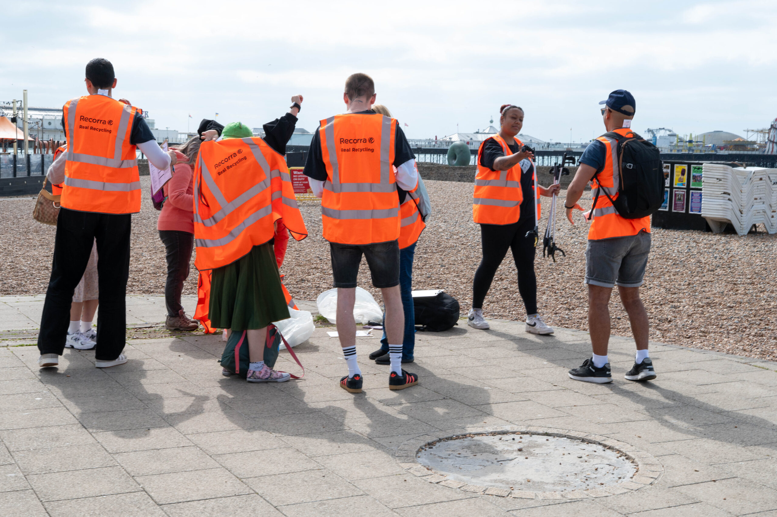 people on the beach with orange vests preparing to clean the beach 