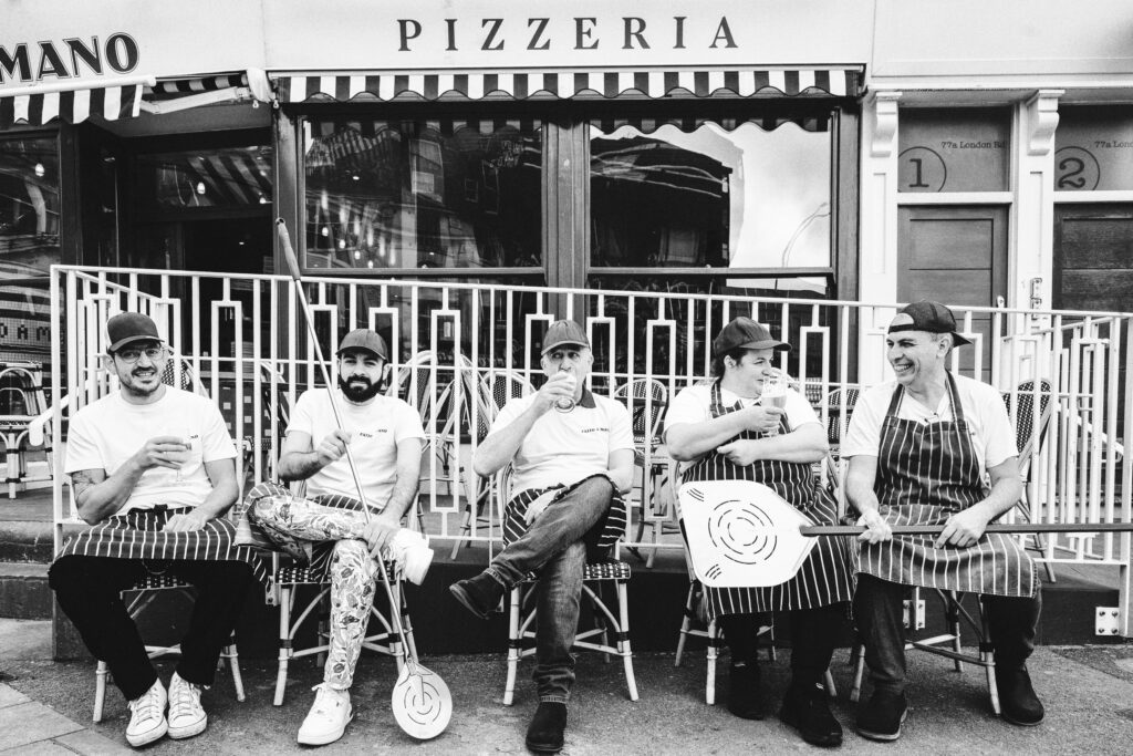 Team photo of people sitting outside Fatto a Mano. Photo credit Xavier Buendia Photography
