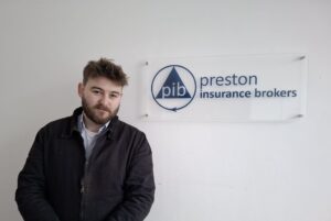Max Merriman at Preston Insurance Brokers, next to the Branding
