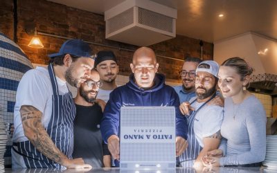 PR_RupertDavidson_FattoAManoPizza-02 A group photo of the team at pizzeria Fatto a Mano all looking into a pizza box.