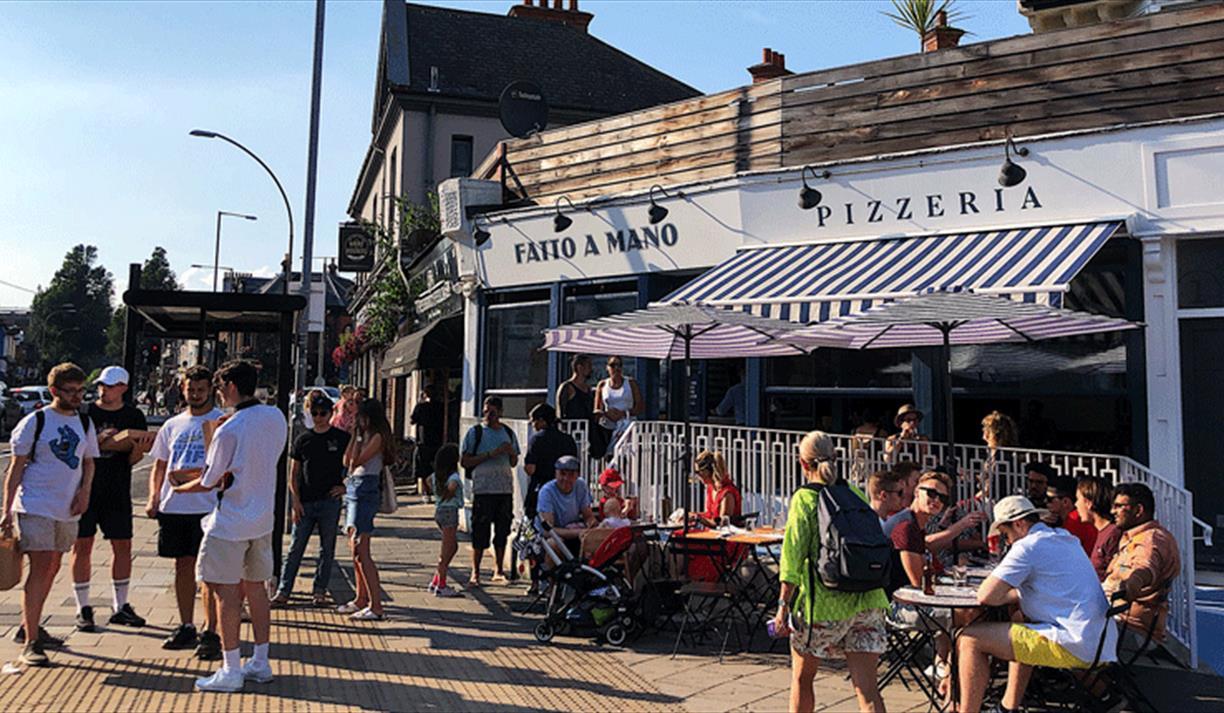 Exterior shot of the Fatto a Mano on Preston Circus, people sittinng outside and enjoying their food and drinks
