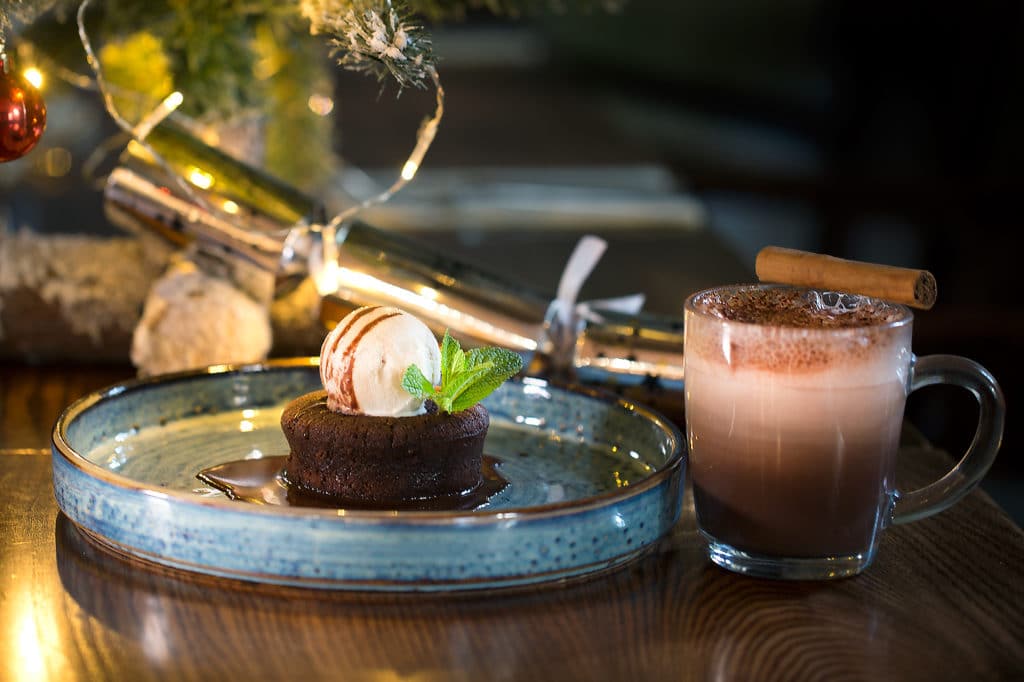 Hot chocolate pudding, chocolate sauce, a scoop of ice cream and a mug of frothy hot chocolate at Hove Place