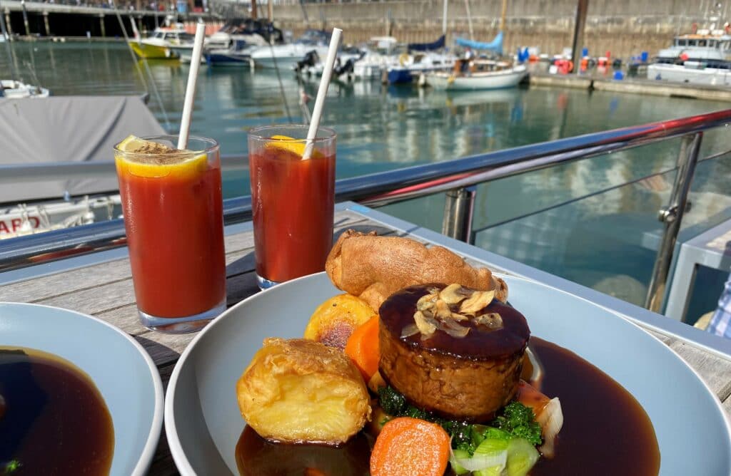 sunday roast on the deck with boats in the background