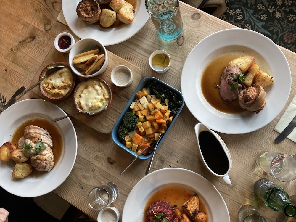 Roast dinners laid out on the table with a selection of sides and gravy