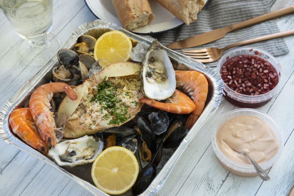 Fresh seafood platter with dipping sauces and crusty bread.