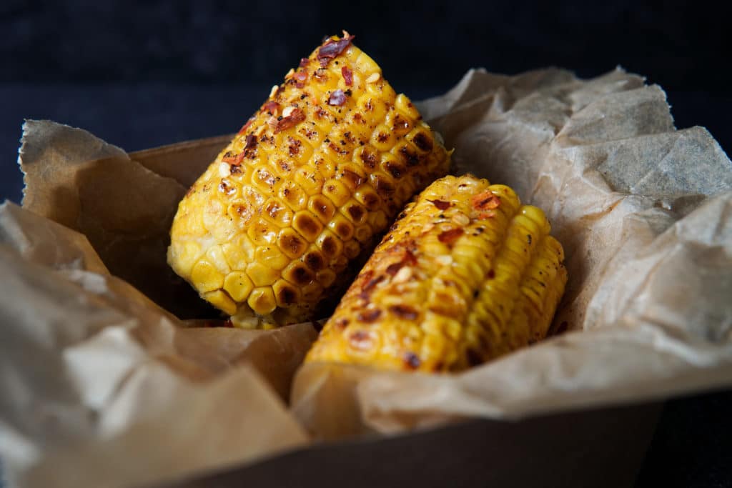 two corn on the cobs, slightly charred and glistening with miso butter, available from Tide Brighton