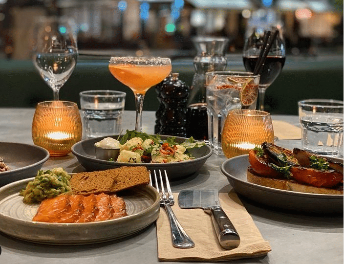 table laid out with small plates, cocktails and wine