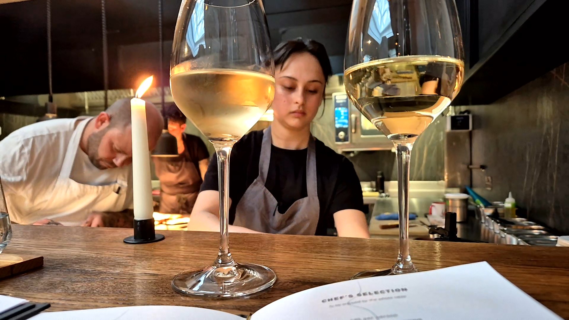 shot of the two glasses of white wine with the two people in the background