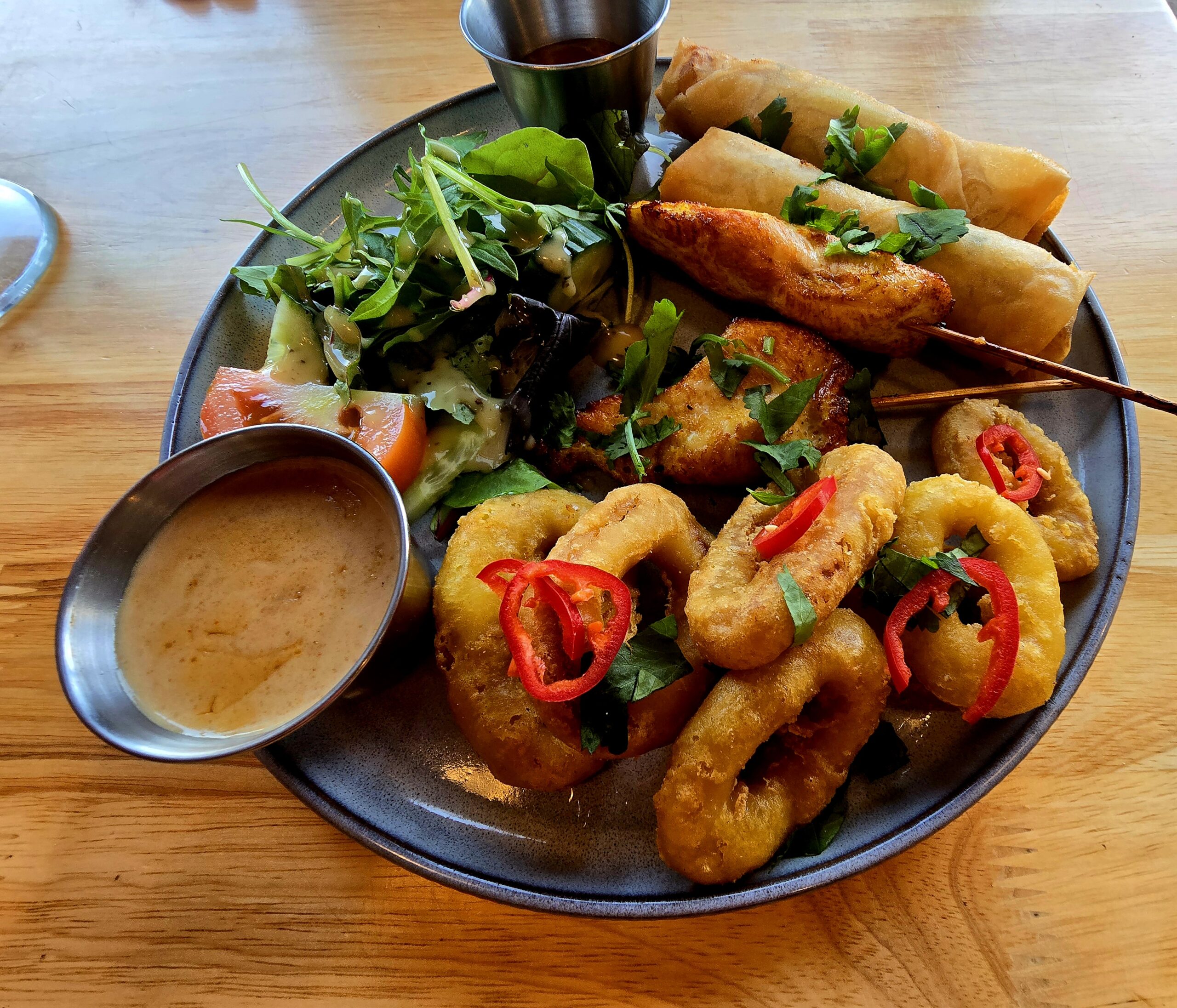 Plate of thai food with spring rolls and some dips
