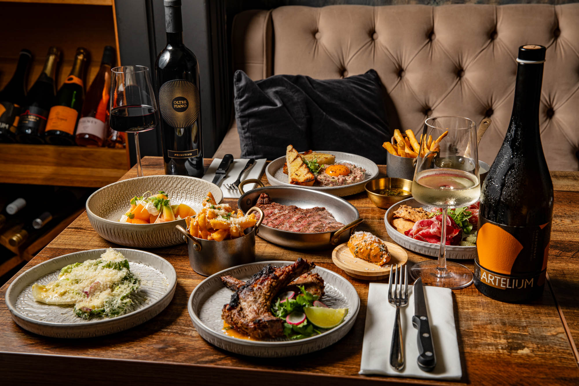 shot of wooden table laid out with many delicious dishes at Carne Hove