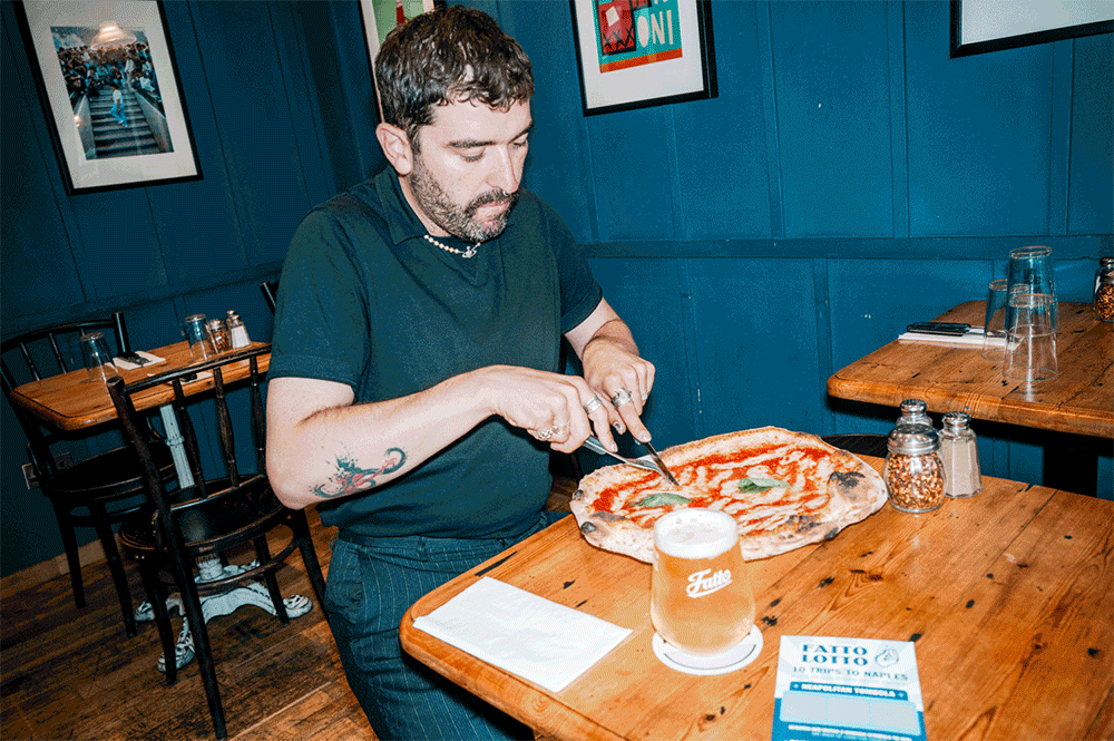 A man posing with Fatto A Mano Pizza