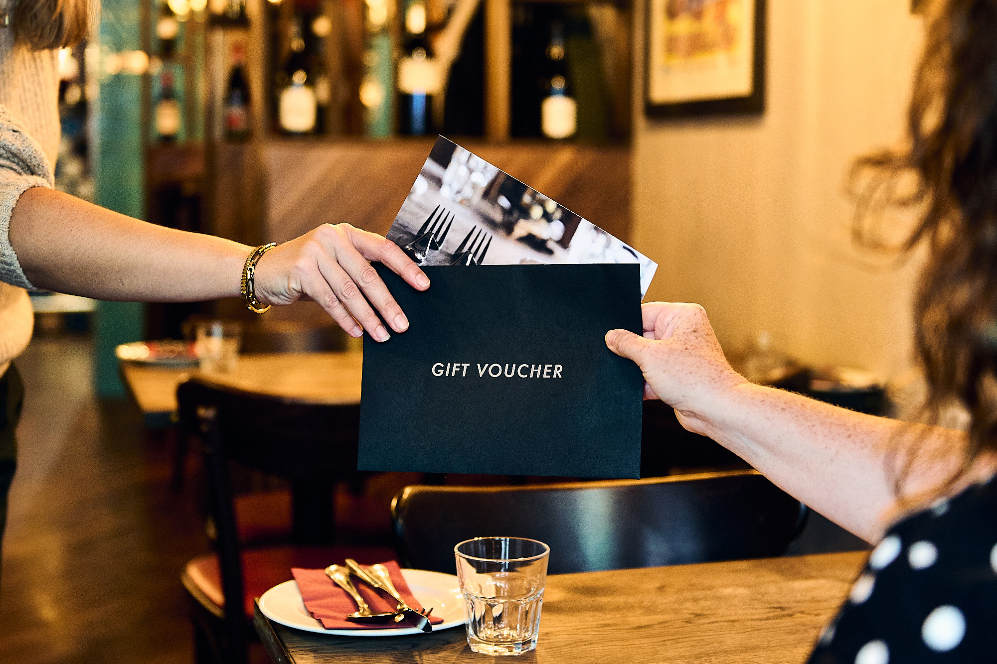 person giving other person a restaurants brighton gift voucher