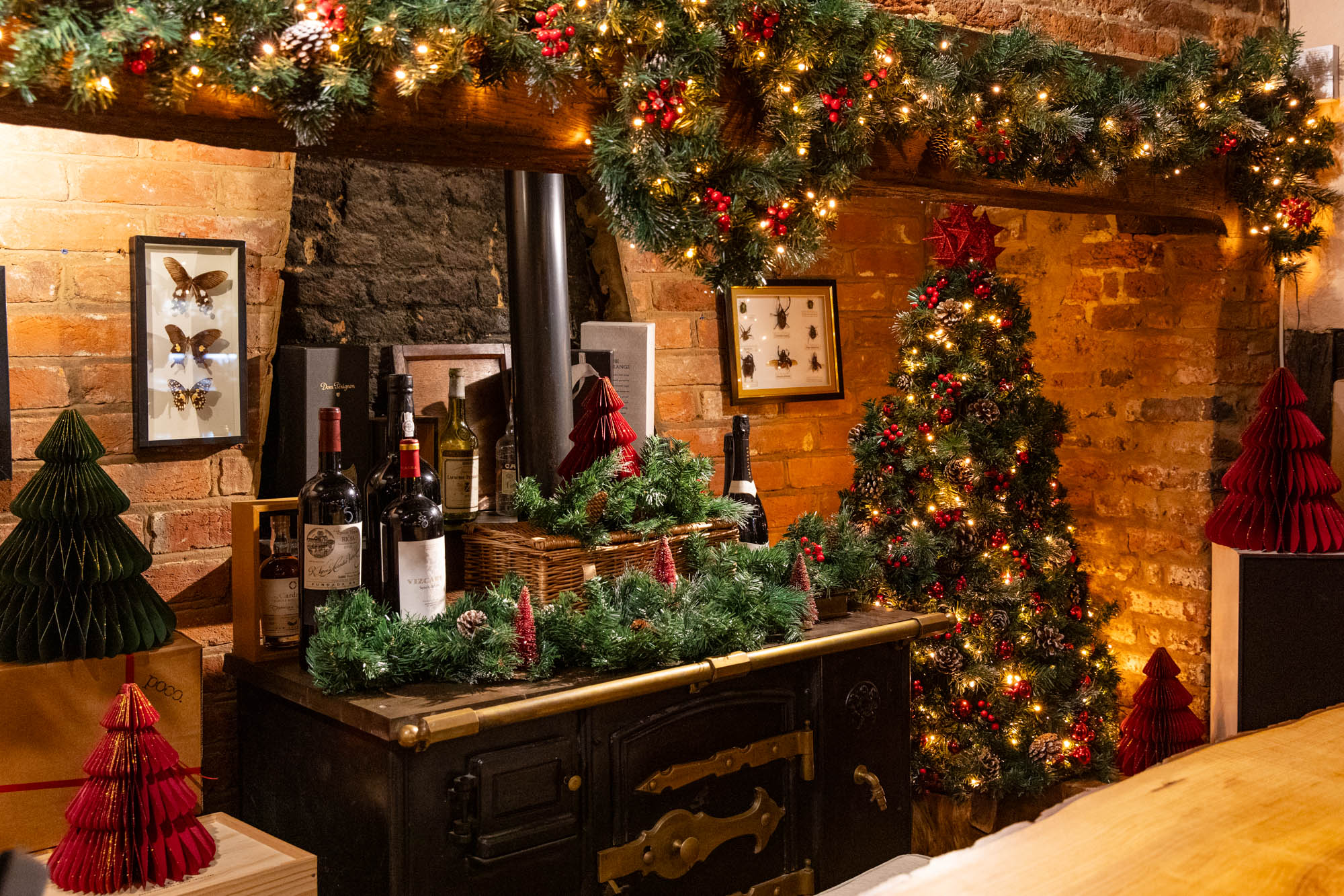 Christmas decorations round a wood burner in a big beautiful brick fireplace at Poco