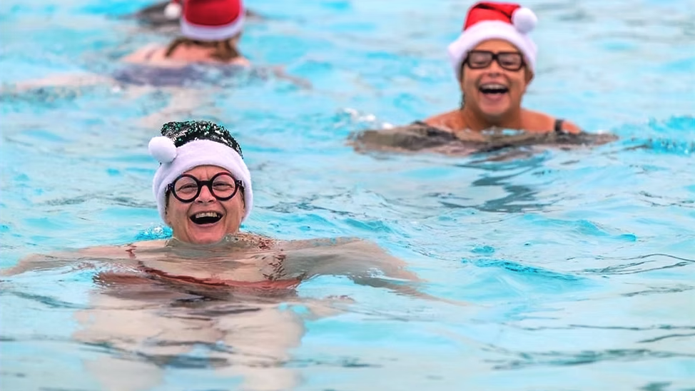 ladies with the christmas hat on swimming