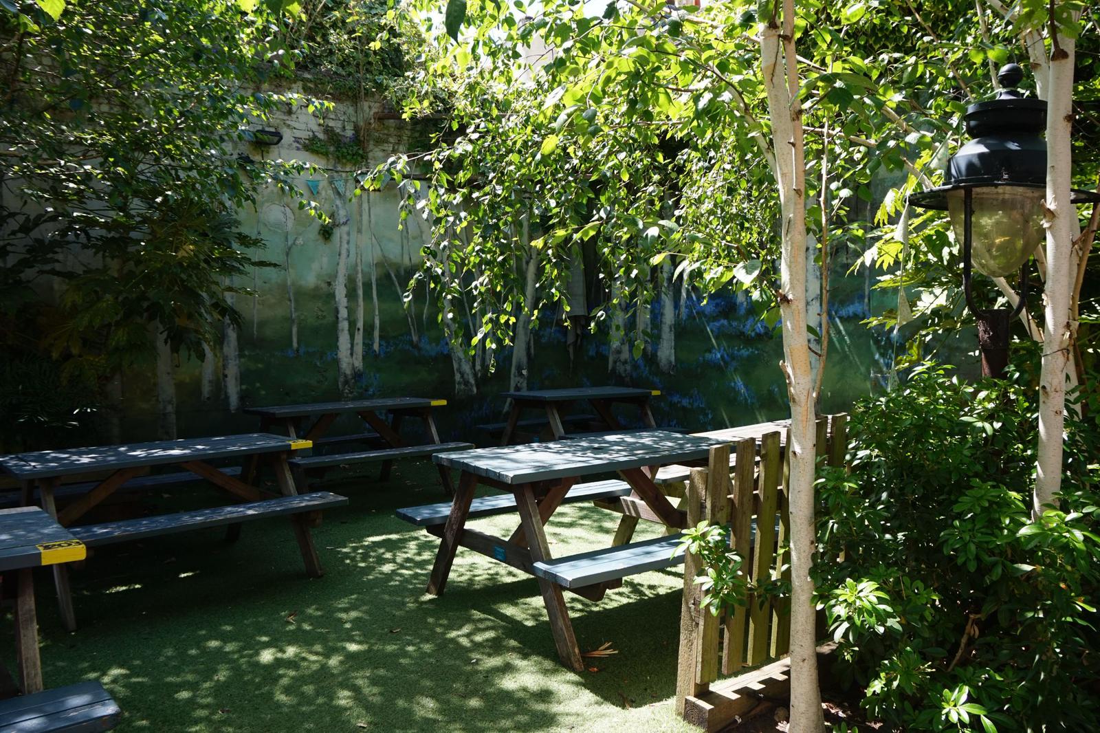 A lush beer garden in Brighton with plants and trees on a sunny day.